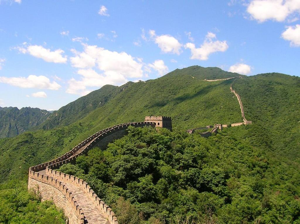 La Gran Muralla China serpenteando entre montañas verdes cerca de Pekín
