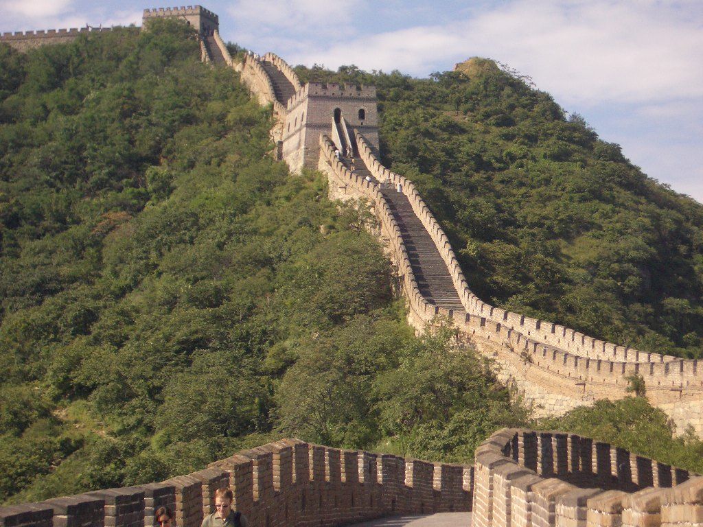 Escalinata empinada de la Gran Muralla en Mutianyu rodeada de bosque